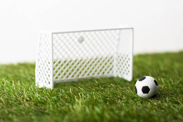 Игрушечные футбольные ворота и мяч на зеленой траве изолированы на белом, концепция спортивных ставок — стоковое фото