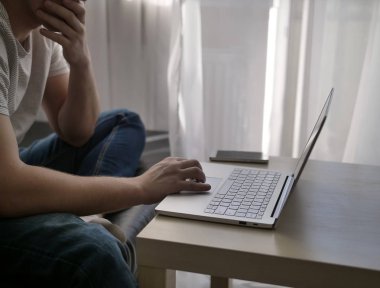 Pencere, yakın çekim evde bir laptop oturan adam