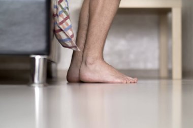 Erkek kıllı bacaklar yatağın yanında