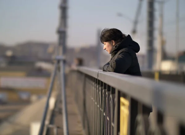 Solitaire jeune fille se tient sur le pont par une journée ensoleillée — Photo