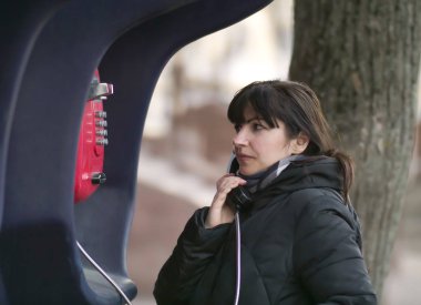 Çekici genç kadın bir sokak ankesörlü telefondan arıyor