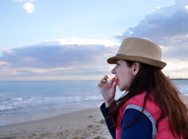 Young attractive woman eats watermelon on the beach near the sea — Stock Photo, Image