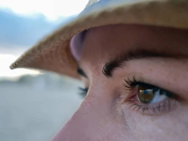 Portrait d'une brune aux yeux bruns avec un chapeau sur le côté, gros plan — Photo