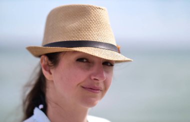 Bir şapka giyen çekici bir kadın portre, gülümseyen ve kamera bakıyor