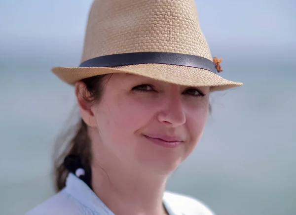 Porträt einer jungen attraktiven Frau mit Hut, die in die Kamera blickt — Stockfoto