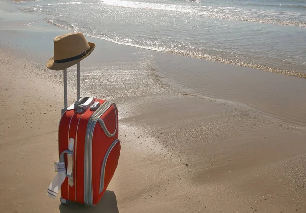 Une valise rouge se dresse sur la plage au bord de la mer, espace pour le texte. Concept de vacances — Photo