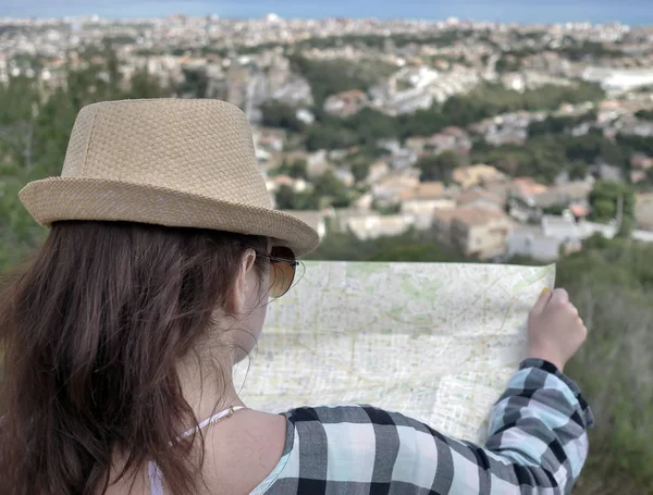 Jolie jeune fille brune avec une carte du village se trouve sur la colline études d'itinéraire de voyage — Photo