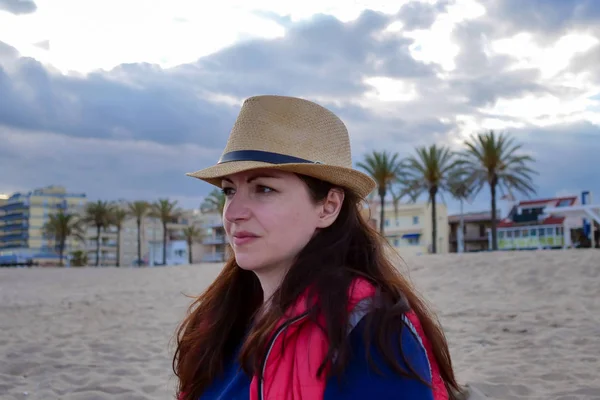 Portrét atraktivní bruneta ve večerním klobouku na pláži — Stock fotografie