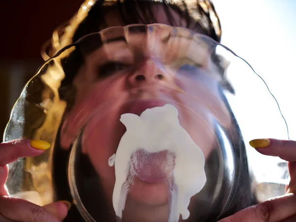 Sexy girl licks a white sauce from a transparent plate — Stock Photo, Image