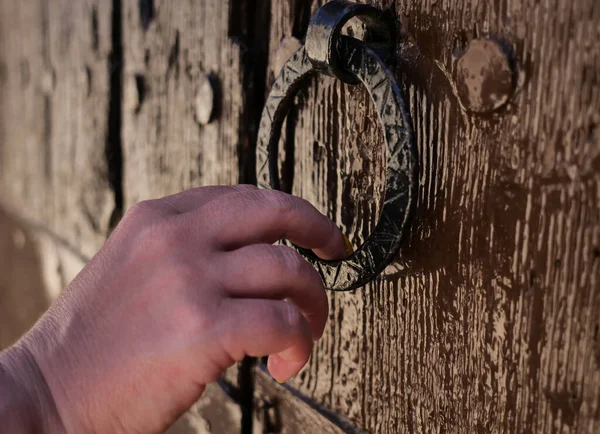 Egy nő kopogtat az ajtón egy kerek kopogtatóval. Stock Kép