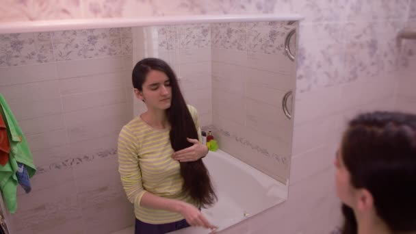 Chica Adolescente Para Baño Delante Del Espejo Peinando Pelo Enmarañado — Vídeo de stock