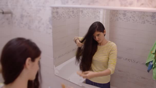 Chica Agradable Adolescente Para Baño Frente Espejo Peinando Pelo Enmarañado — Vídeo de stock