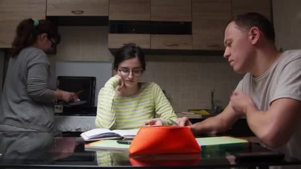 爸爸和女儿晚上在厨房做作业 妈妈做饭 — 图库视频影像