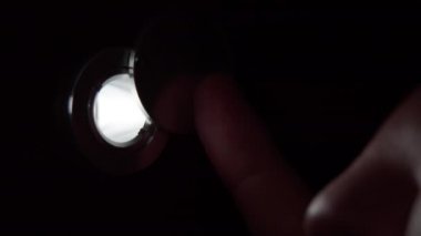 Gözetleme deliğinden bakan adam, yakın plan.