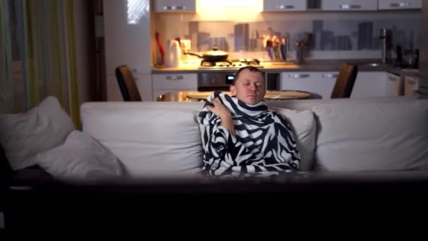 Chory Mężczyzna Siedzi Kanapie Wieczorem Ogląda Telewizję Ruch Kamery — Wideo stockowe