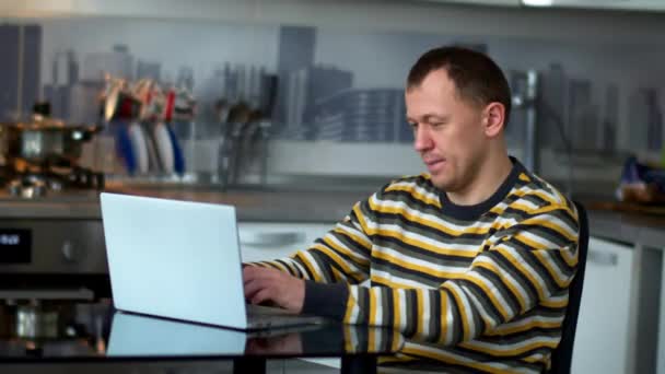 Чоловік Працює Ноутбуці Сидячи Вдома Кухні — стокове відео