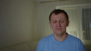 Ağlayan adam pencereye doğru uzanmış bir mendil alır.