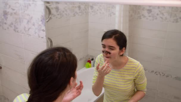 Μια Έφηβη Στέκεται Στο Μπάνιο Μπροστά Από Έναν Καθρέφτη Και — Αρχείο Βίντεο