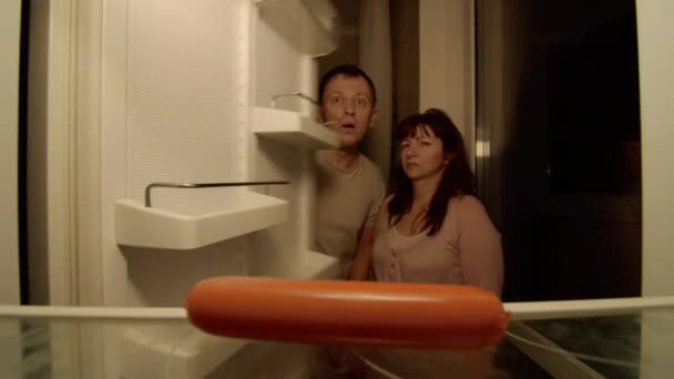 Супружеская Пара Открывает Холодильник Почти Пуст Удивляются Женщина Хватает Сосиску — стоковое видео