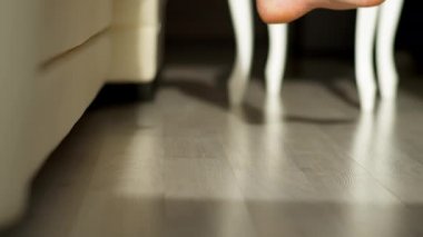 Güneşli bir sabah, bir adam yataktan çıkar, çıplak ayakla yere basar.