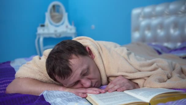 Unavený Muž Spí Posteli Ložnici Vedle Otevřené Knihy — Stock video
