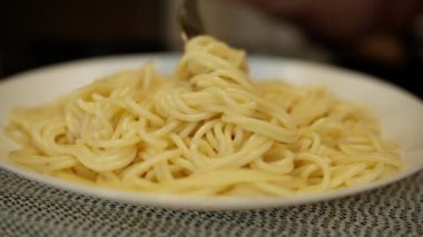 Mutfak masasında spagetti olan beyaz tabak, yakın plan.