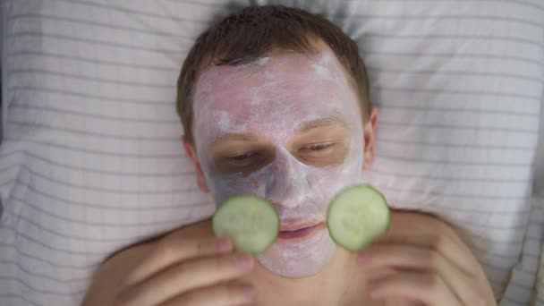 Junger Attraktiver Mann Mit Kosmetikmaske Gesicht Und Gurkenscheiben Auf Den — Stockvideo