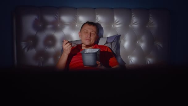 Sonriente Hombre Encuentra Noche Cama Junto Televisor Con Cubo Helado — Vídeo de stock