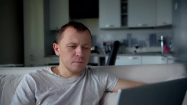 Dizüstü bilgisayarda çalışan serbest çalışan, koltukta oturan, uzaktan kumandalı biri.