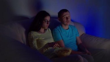 Genç bir çiftin televizyon karşısında oturup cips yediği sıkıcı bir akşam.