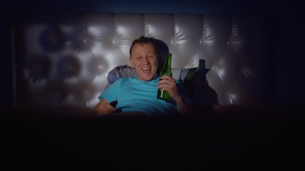 Młody Człowiek Oglądający Nocną Telewizję Butelką Piwa Oglądający Zabawny Śmiech — Wideo stockowe