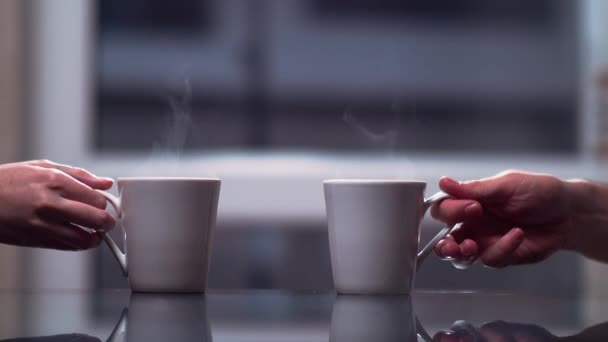 Två vita keramiska muggar på bordet en man och en kvinna ta dem och sätta dem tillbaka, närbild, bakgrunden till ett fönster — Stockvideo