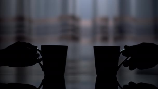 两只瓷杯的深色轮廓 一个男人的手和一个女人的手从桌子上拿起 — 图库视频影像