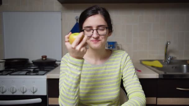 Chica Gafas Sienta Mesa Cocina Come Una Manzana Mira Cámara — Vídeos de Stock