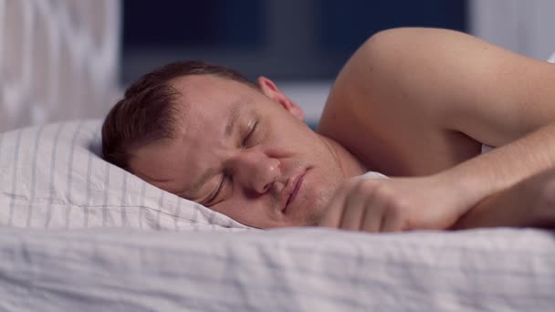 男人因为噪音睡不着觉 就用枕头捂住耳朵 — 图库视频影像