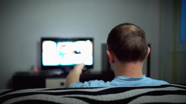 Μόνος Άνθρωπος Βλέποντας Τηλεόραση Βράδυ Κάθεται Στον Καναπέ Πίσω Όψη — Αρχείο Βίντεο