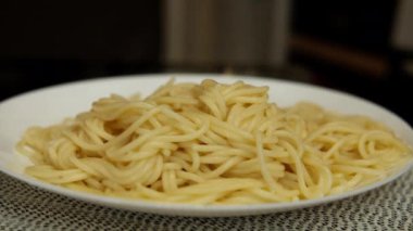 Taze pişmiş spagetti dolu beyaz tabak, buhara git ve kapat.