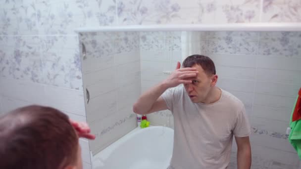 Волосы Молодого Человека Выпадают Расстроен Видит Зеркале — стоковое видео