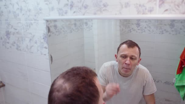 Man Plukt Haar Uit Zijn Neus Staat Badkamer Voor Een — Stockvideo