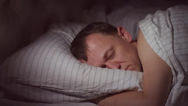 Ung Man Sover Tyst Natten Sin Säng Ljuset Från Nattlampa — Stockvideo