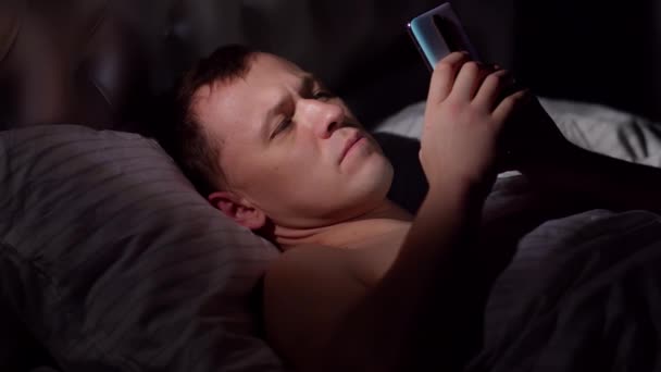 Een Jonge Man Ligt Avonds Laat Bed Met Een Mobiele — Stockvideo