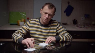 Genç bir adam çıkartmalara gelecek için planlarını yazar. Akşamları mutfak masasında oturur, bir şeyler planlar.