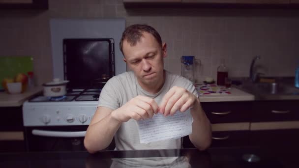 Злой Человек Разрывает Лист Бумаги Мелкие Кусочки Сидит Вечером Кухне — стоковое видео