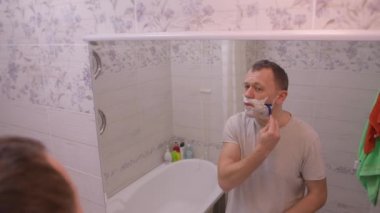Bir adam tıraş olur, aynada kendine bakar, dikiz aynası, kamera hareketi