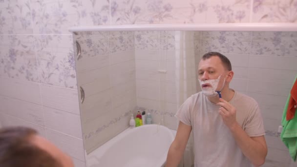 Man Shaves His Beard Morning Standing Bathroom Mirror Camera Movement — Stock Video