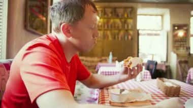 Kafede otururken taco yiyen bir adam, kamera hareketi.