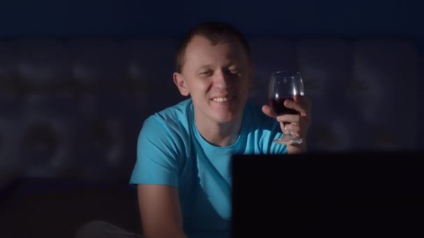 Junger Mann Mit Einem Glas Rotwein Vor Dem Fernseher Der — Stockvideo