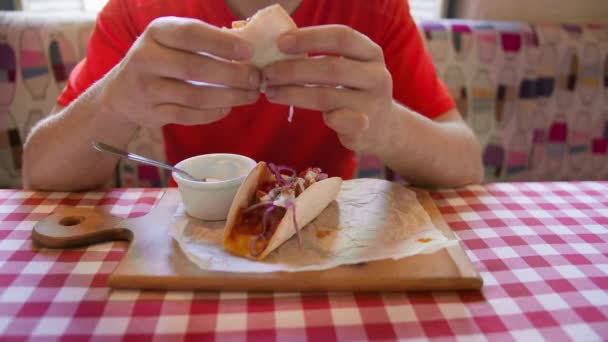 在木板上的两个玉米饼和酱汁 在街上咖啡店的桌子上一个男人在吃饭 镜头在移动 — 图库视频影像
