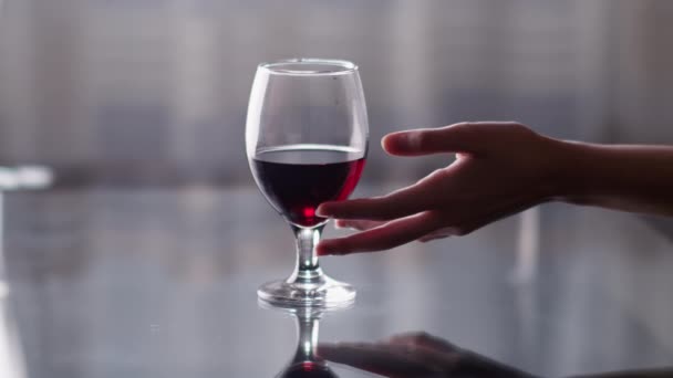 优雅的女性的手从桌子上拿起一杯红酒 淡淡的背景 — 图库视频影像