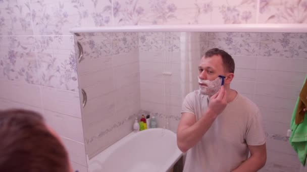 Un jeune homme se rase le matin prend des procédures d'hygiène, mouvement de la caméra — Video
